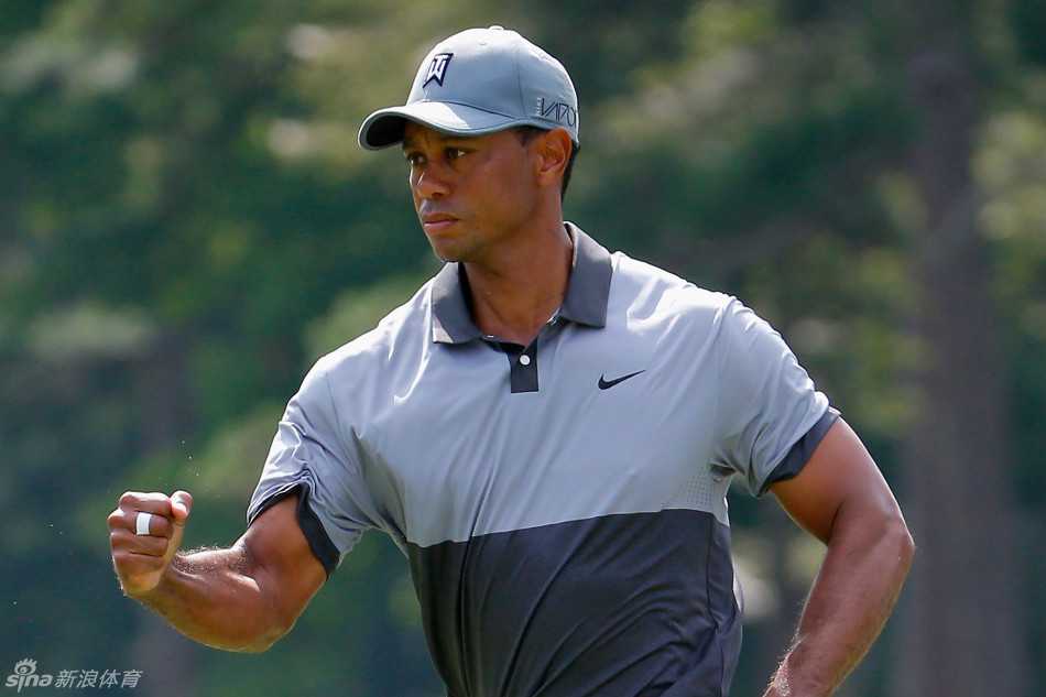 在果岭边缘，伍兹紧握推杆，眉头微蹙进行关键一推，周遭的观众屏息凝神。