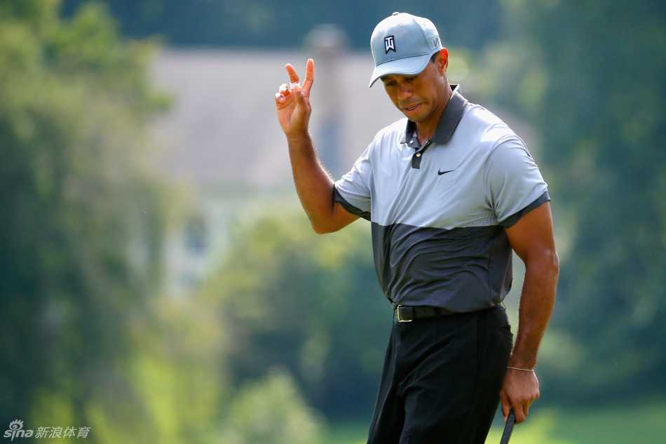 伍兹在沙坑中奋力救球，沙粒飞扬，展现了他永不放弃的比赛态度。