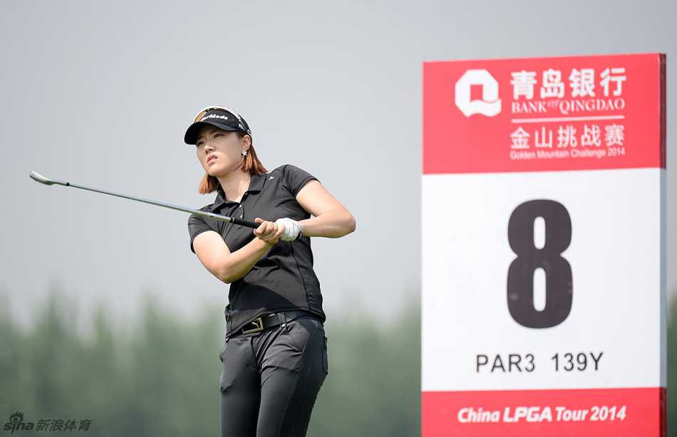 韩国球手朴镇希在开球前凝神准备，阳光勾勒出她专注的侧影，球杆在绿地的映衬下闪烁着光芒。