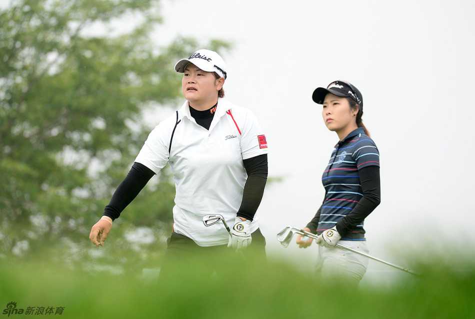 泰国选手哈泰莰优雅挥杆，白色的上衣与湛蓝的天空形成鲜明对比，整套动作流畅而充满力量感。