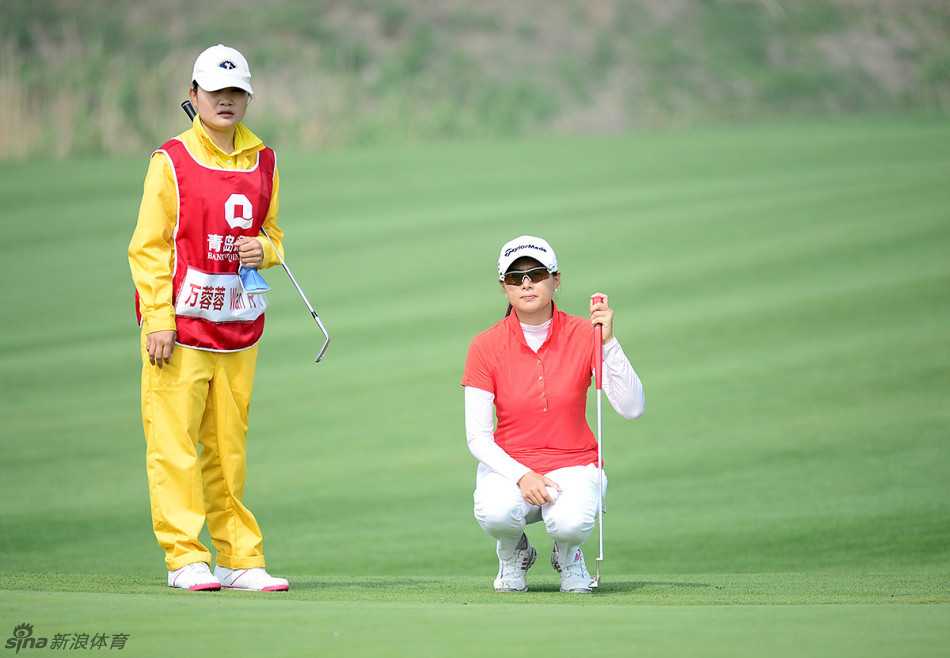 肖薏在果岭边缘进行切球，她全神贯注地瞄准目标，周围的沙坑与短草区考验着她精准的短杆技术。