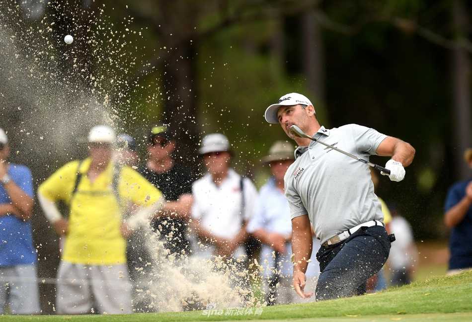 冠军亚当·斯科特高举奖杯向观众致意，银色奖杯与身后绿茵场交相辉映，定格王者归来的经典瞬间。