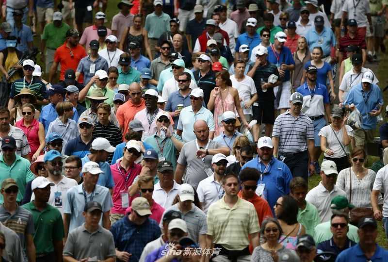 亲切的球星安德鲁·乔斯顿弯下腰，与他的两位小球迷并肩合影，三人脸上都洋溢着开心灿烂的笑容。