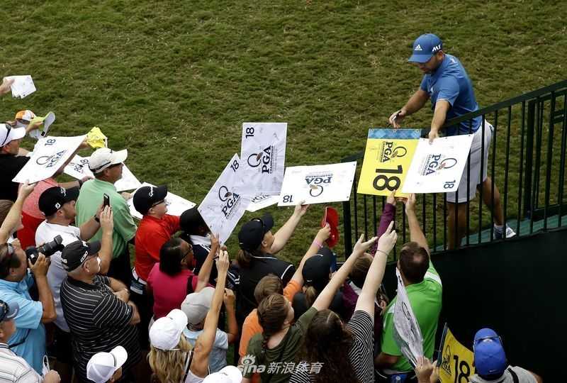 两位年轻的小球迷高举着刚刚获得的签名果岭旗，脸上写满了成功的兴奋与骄傲，仿佛赢得了最珍贵的奖杯。