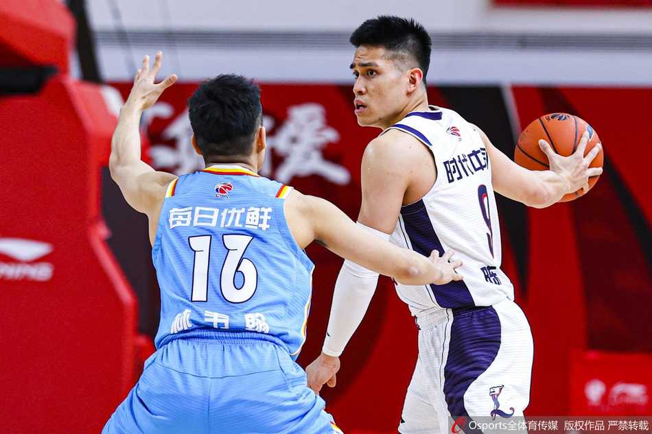 青岛队巨塔约翰逊在三人围堵中强行起跳，指尖轻挑篮球划过一条完美弧线飞向篮筐