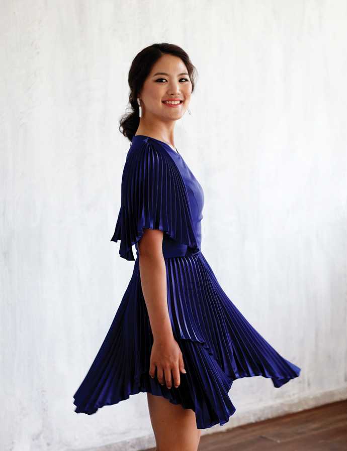 柳箫然侧身凝望，眼神坚定而温柔，身后绿茵场与蔚蓝天空构成宁静画卷