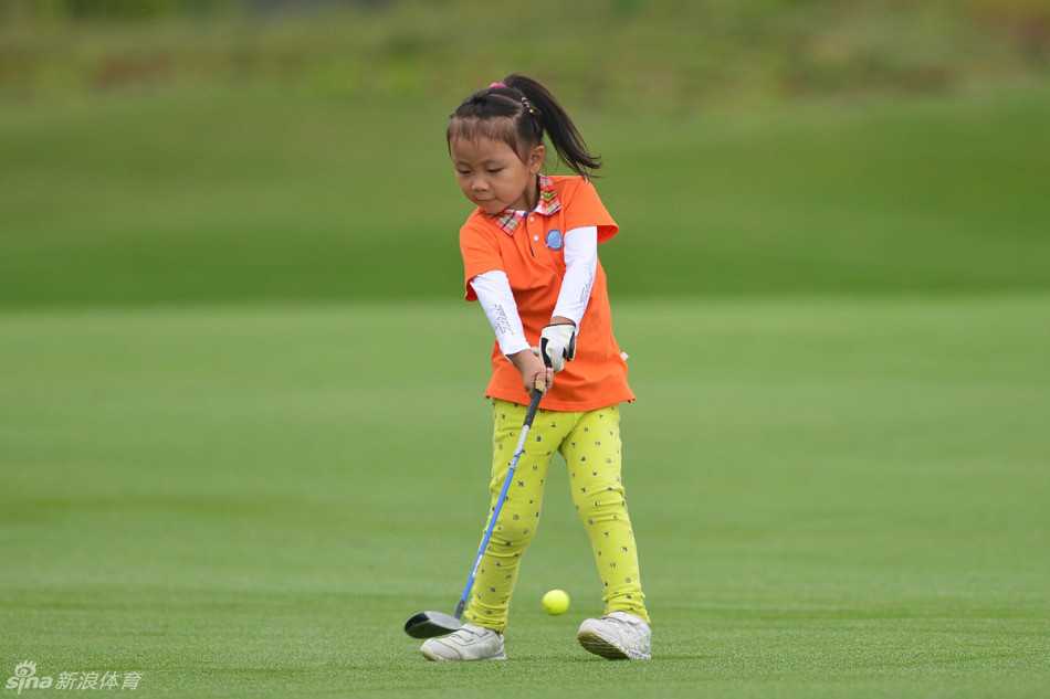 比赛间隙，父亲坐在草地上，仔细地为女儿的水壶装上吸管，孩子则靠着他休息，父女相依的侧影在草坪上显得格外宁静与美好。