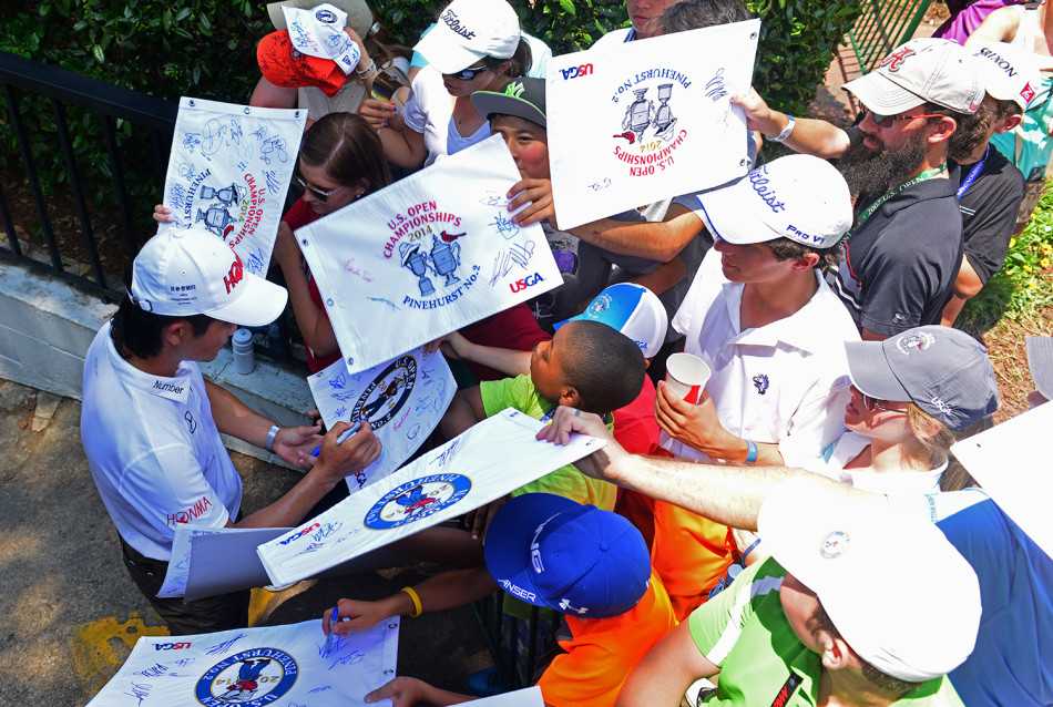 梁文冲与球童Koji-Manabe在赛道上专注商讨战术，默契无间