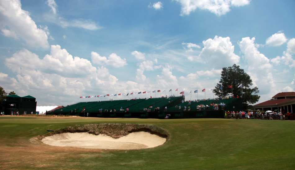 梁文冲在松树丛2号场极具挑战的18号洞果岭上专注研判推杆线路