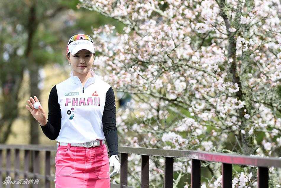 石昱婷漫步于如雪樱花树下，粉色花瓣雨般飘落在她坚定的身影周围，仿佛一场为她而设的冠军加冕礼
