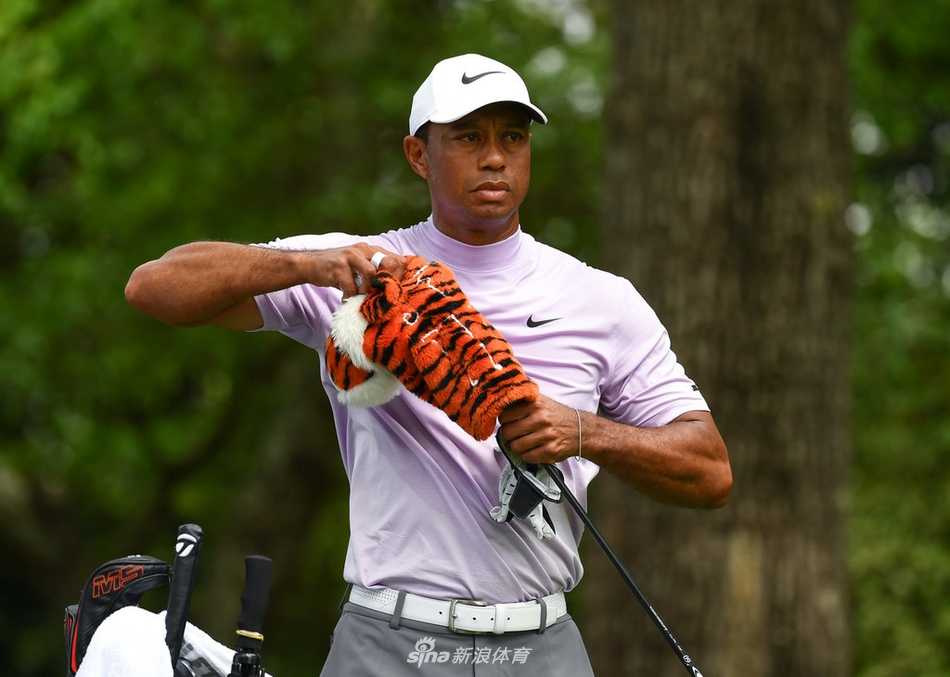 观众簇拥在奥古斯塔球道两旁，人群中伍兹与球童一同分析下一杆策略，氛围紧张而热烈。