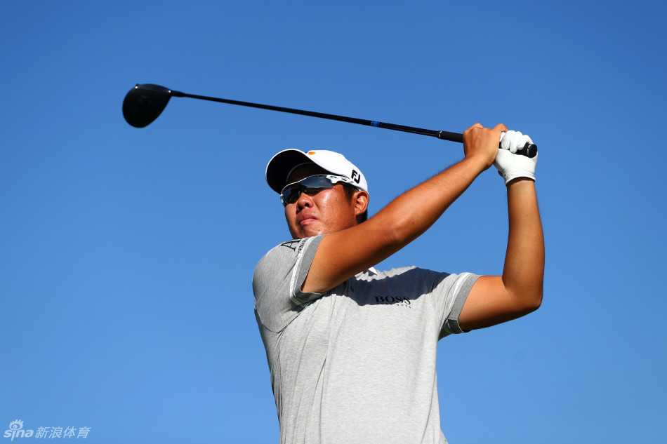 赛事现场鸟瞰图，展示出球道、沙坑与水塘组成的精美布局，球员们正在其间竞技。