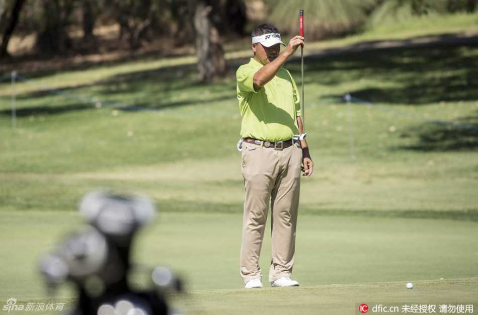 美国球手皮特·尤莱在佳瑞浦湖球场果岭边冷静观察推杆线路，神情专注