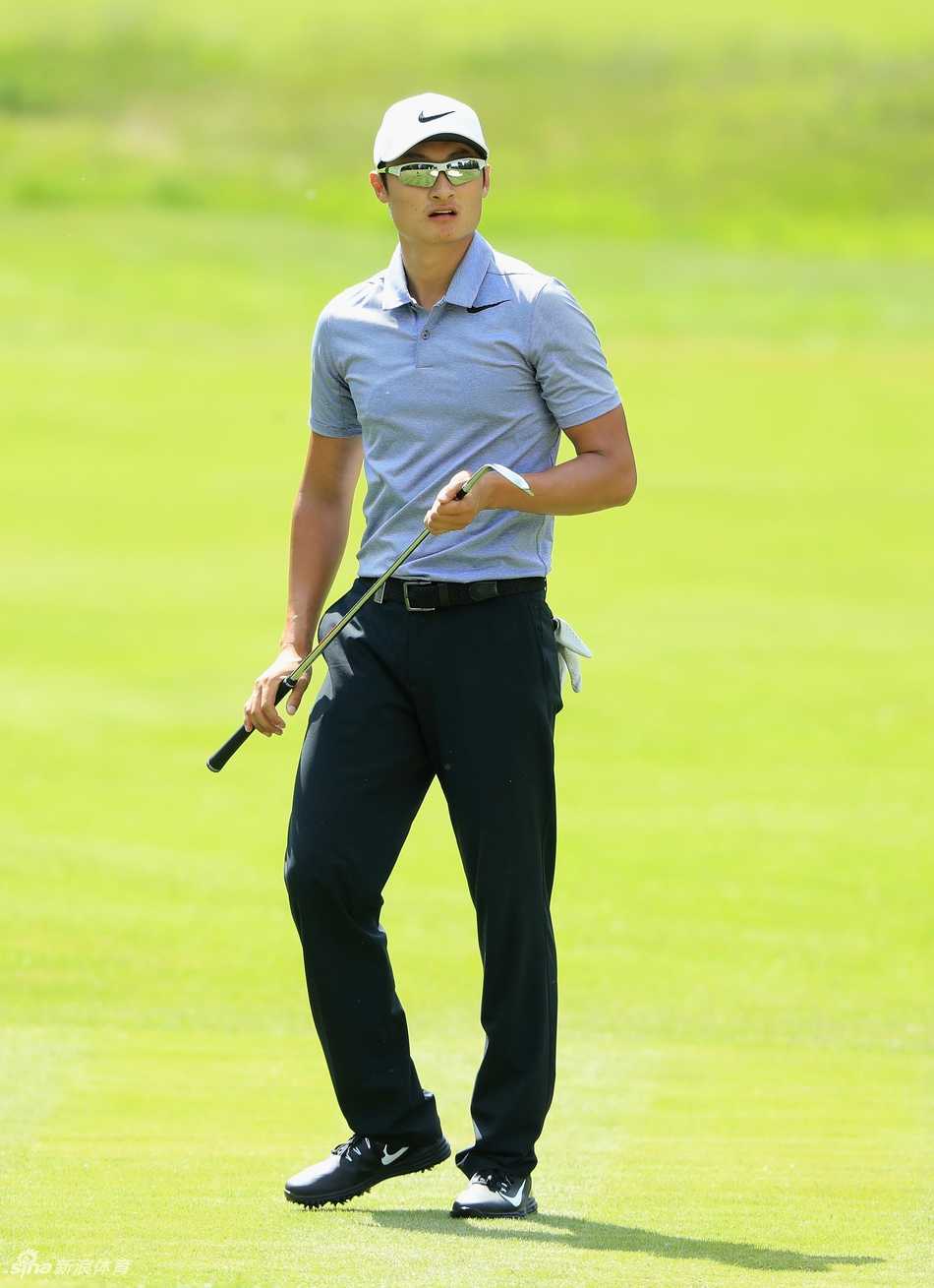 李昊桐在练习场进行赛前热身拉伸，背影专注而充满力量感