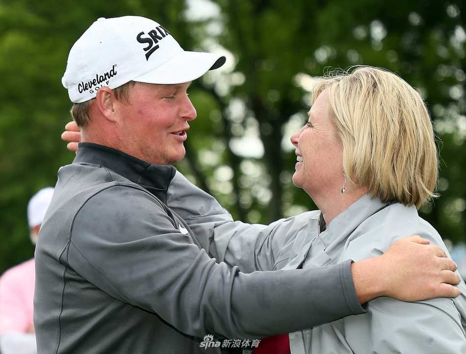 冠军吉勒曼在粉红果岭旗旁优雅挥杆，阳光勾勒出他专注的侧影，动作流畅而充满力量。