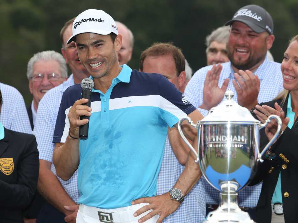 冠军毕耶加斯深情凝视手中奖杯，聚光灯下奖杯熠熠生辉，映照着他历经艰辛后的灿烂笑容