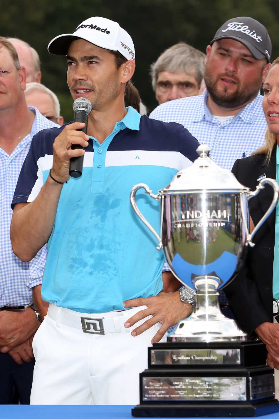 所有赛事参与者齐聚果岭进行大合影，色彩鲜艳的服装点缀在绿色草坪上，充满欢乐与团结的庆典氛围