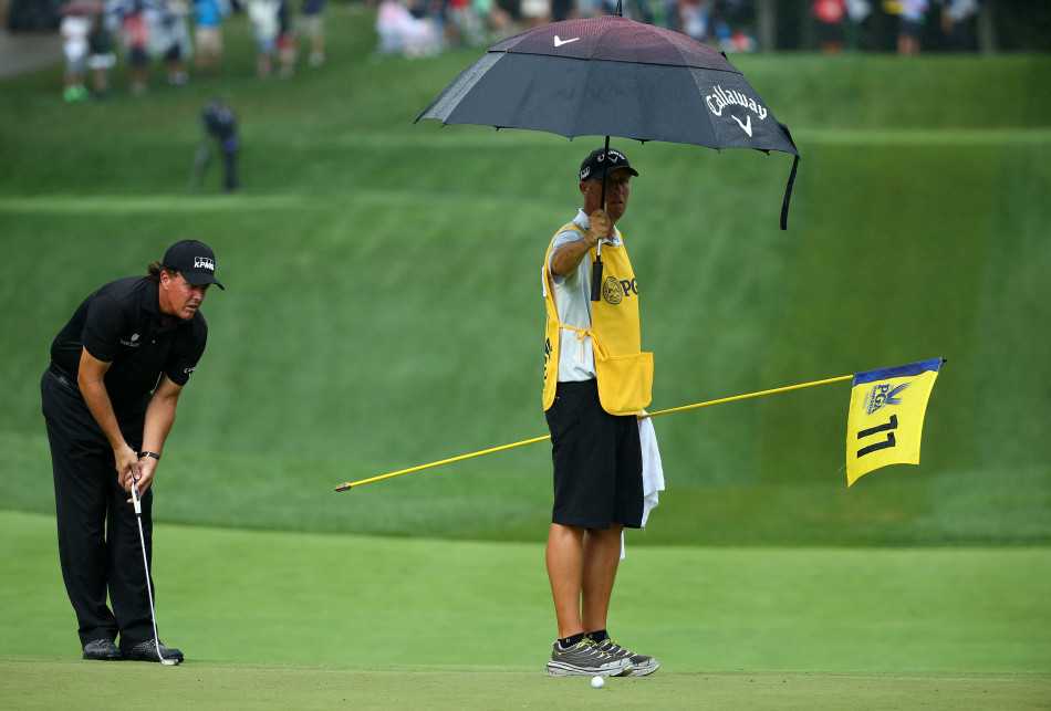 巴巴·沃森在第18洞水障碍前凝神准备击球，水面倒映着他沉思的身影，风险与机遇在此一杆之间。