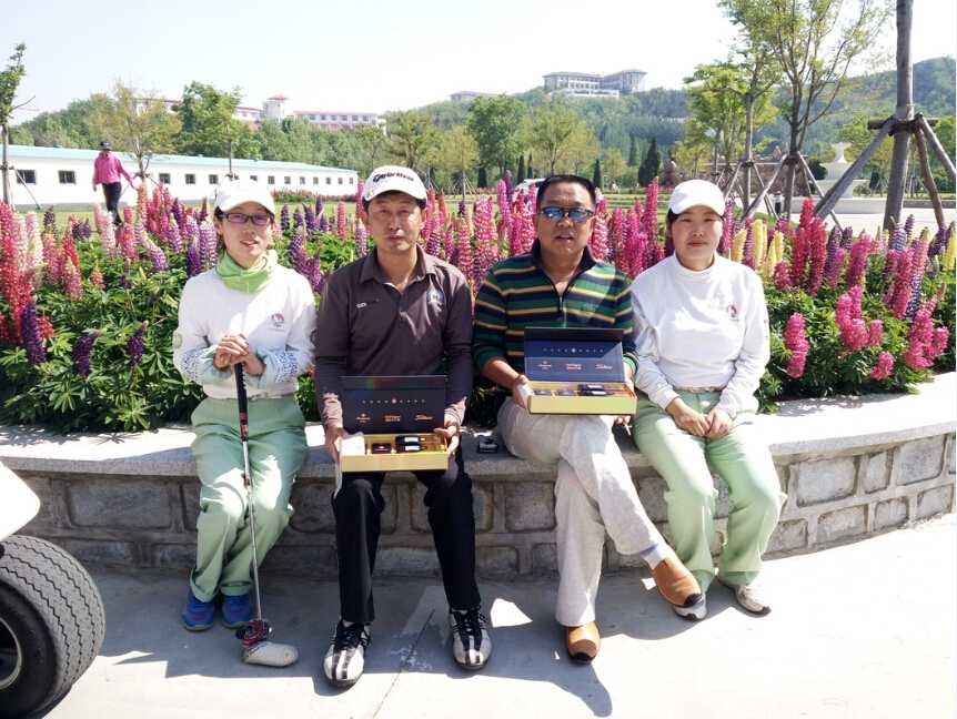 阳光洒落在翠绿果岭上，印有‘百鸟争鸣’主题的芙蓉王大型艺术礼盒优雅陈列，与远处挥杆的身影构成一幅和谐画卷。