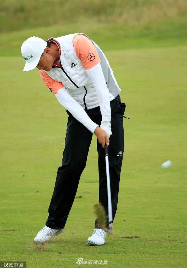 李昊桐背对镜头走向下一个球洞，孤独而坚定的身影融入皇家波特拉什辽阔的球场与天空之中，象征着高尔夫球员的漫漫征途。