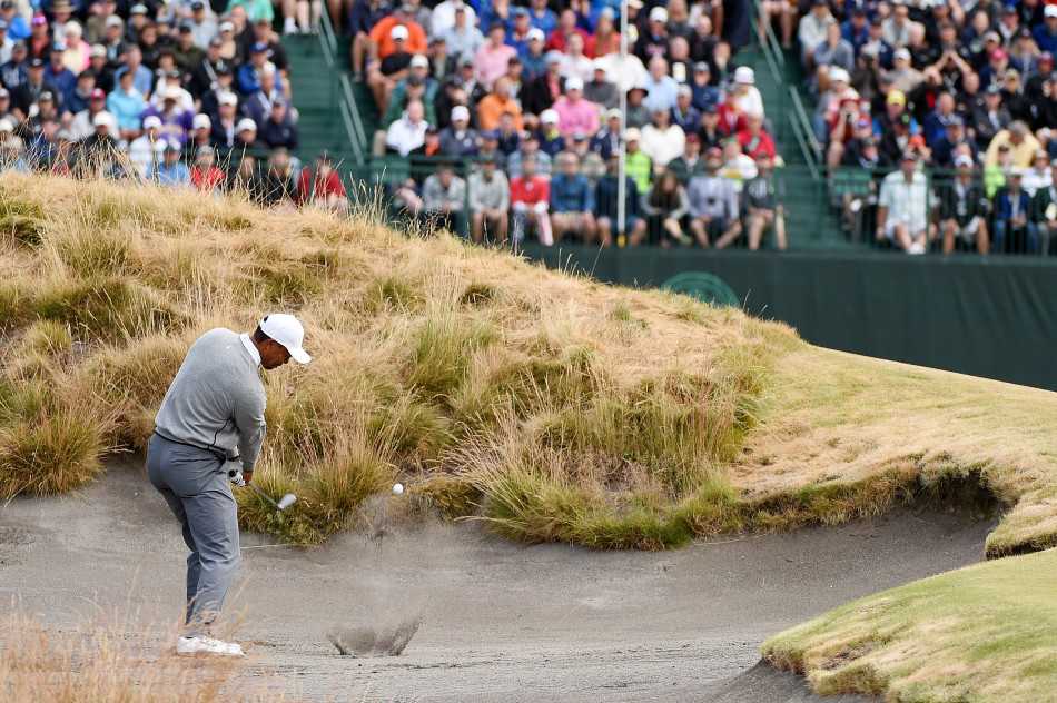 伍兹在沙坑中完成一次漂亮的救球后，小球划过一道优雅弧线飞向果岭，他的身体随着完整的送杆动作自然伸展。