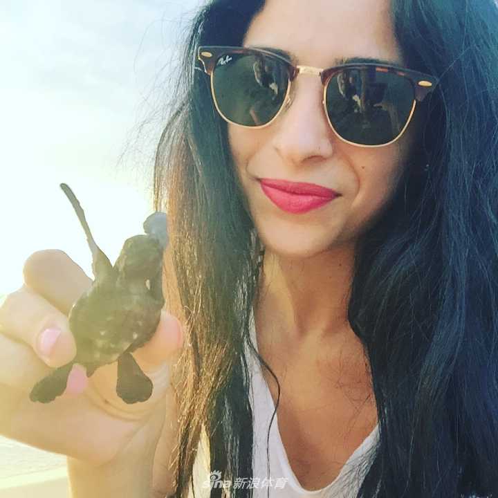 路易莎手持奖杯站在领奖台上，向观众挥手致意，脸上洋溢着胜利的喜悦与谦和