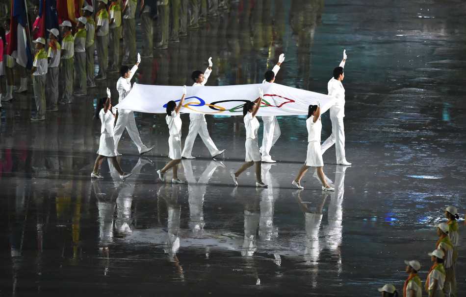 窦泽成在高尔夫球场上专注挥杆的瞬间，背景是葱郁的钟山球场，他的动作舒展而充满力量