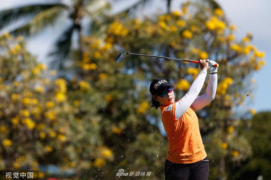 莫莉娅在蔚蓝天空与洁白沙坑的映衬下，正在果岭边仔细斟酌切杆选择