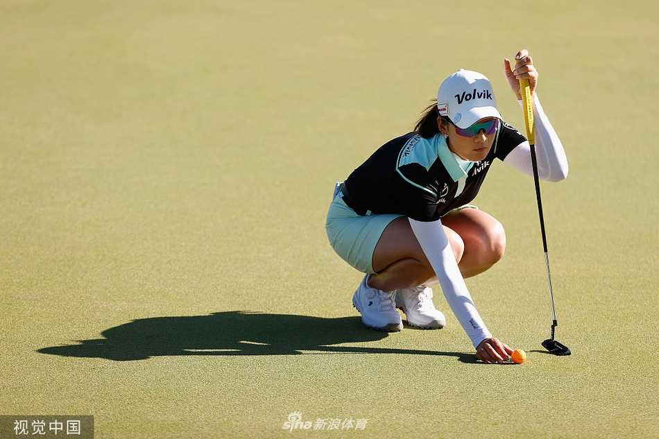 崔芸精在观众的注目中推击关键一推，果岭的线条与她的专注神情共同构成了紧张的比赛氛围