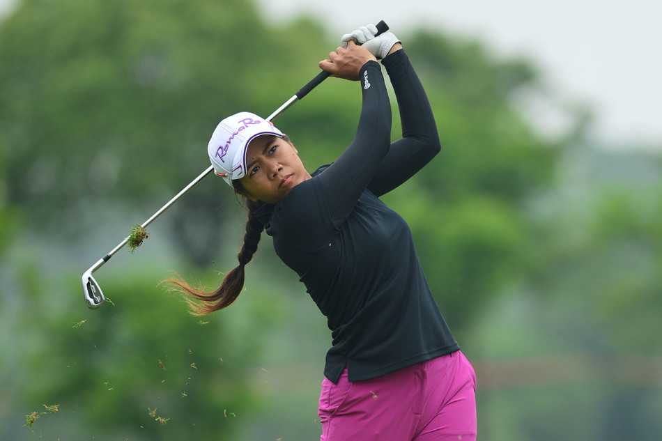 郭彩竹俯身果岭，全神贯注地准备关键推杆，决胜于一瞬之间