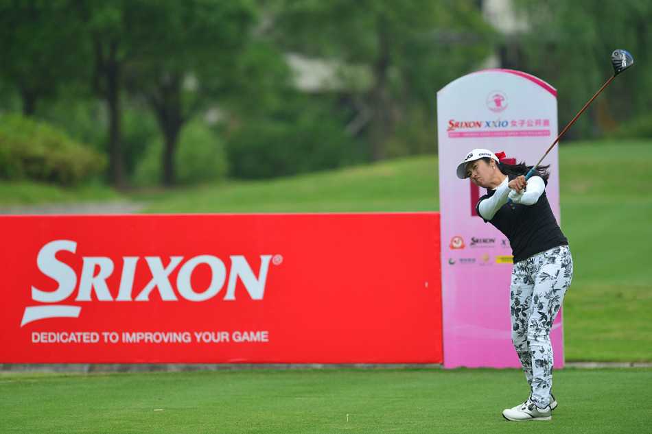 卢月霞在观众注目下潇洒收杆，脸上洋溢着完成挑战后的自信笑容